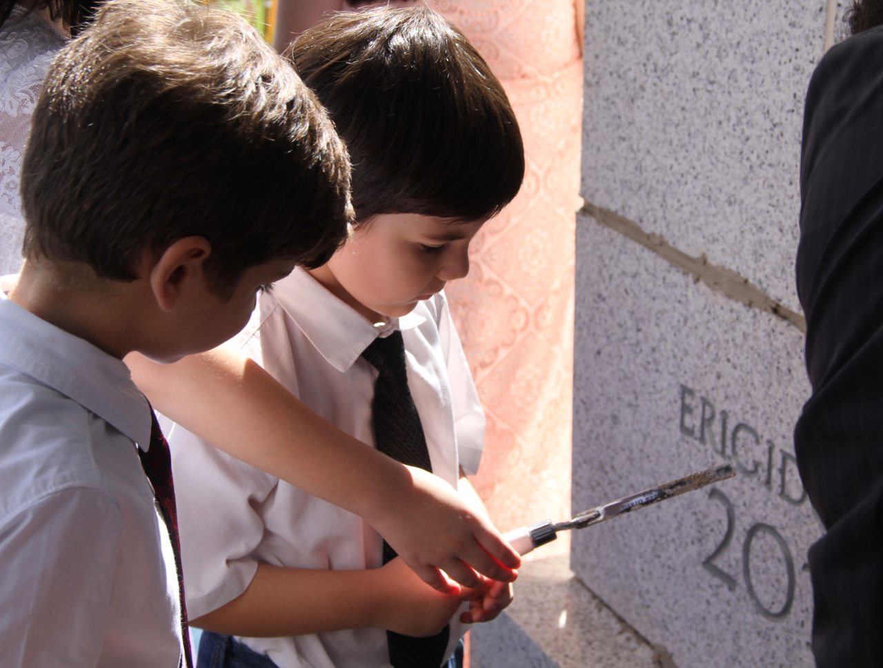 Children take turns applying mortar to the cornerstone of the Fortaleza Brazil Temple after the cornerstone ceremony had concluded Sunday, June 2, 2019.