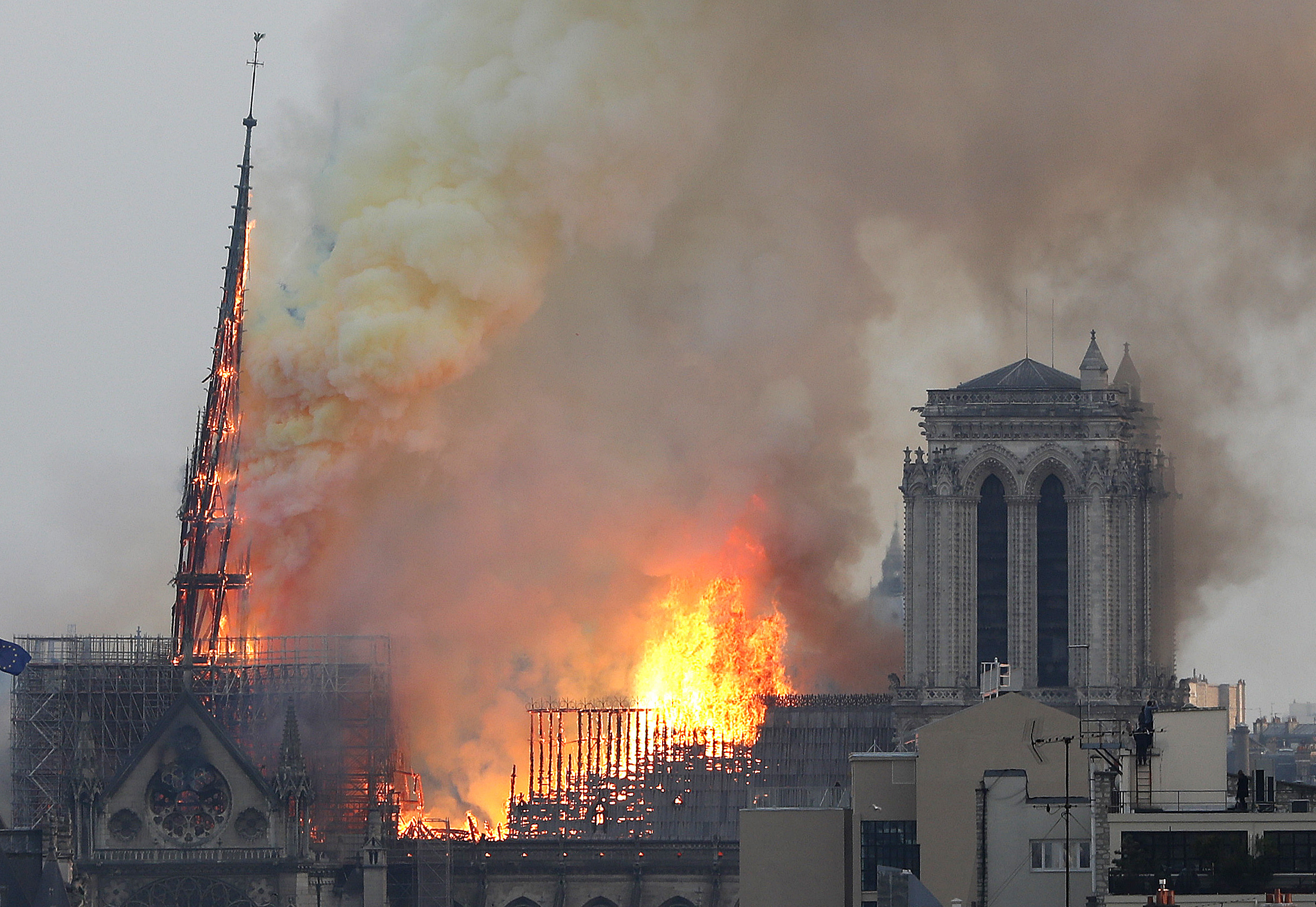 Flames rise from Notre Dame cathedral as it burns in Paris, Monday, April 15, 2019. Massive plumes of yellow brown smoke is filling the air above Notre Dame Cathedral and ash is falling on tourists and others around the island that marks the center of Paris. (AP Photo/Thibault Camus)