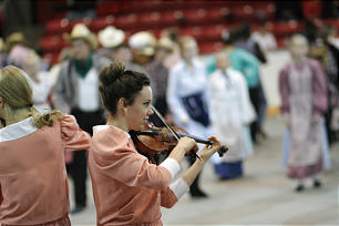 A fiddler plays for young people to do line dancing during the cultural program in Calgary's Stampede Corral.