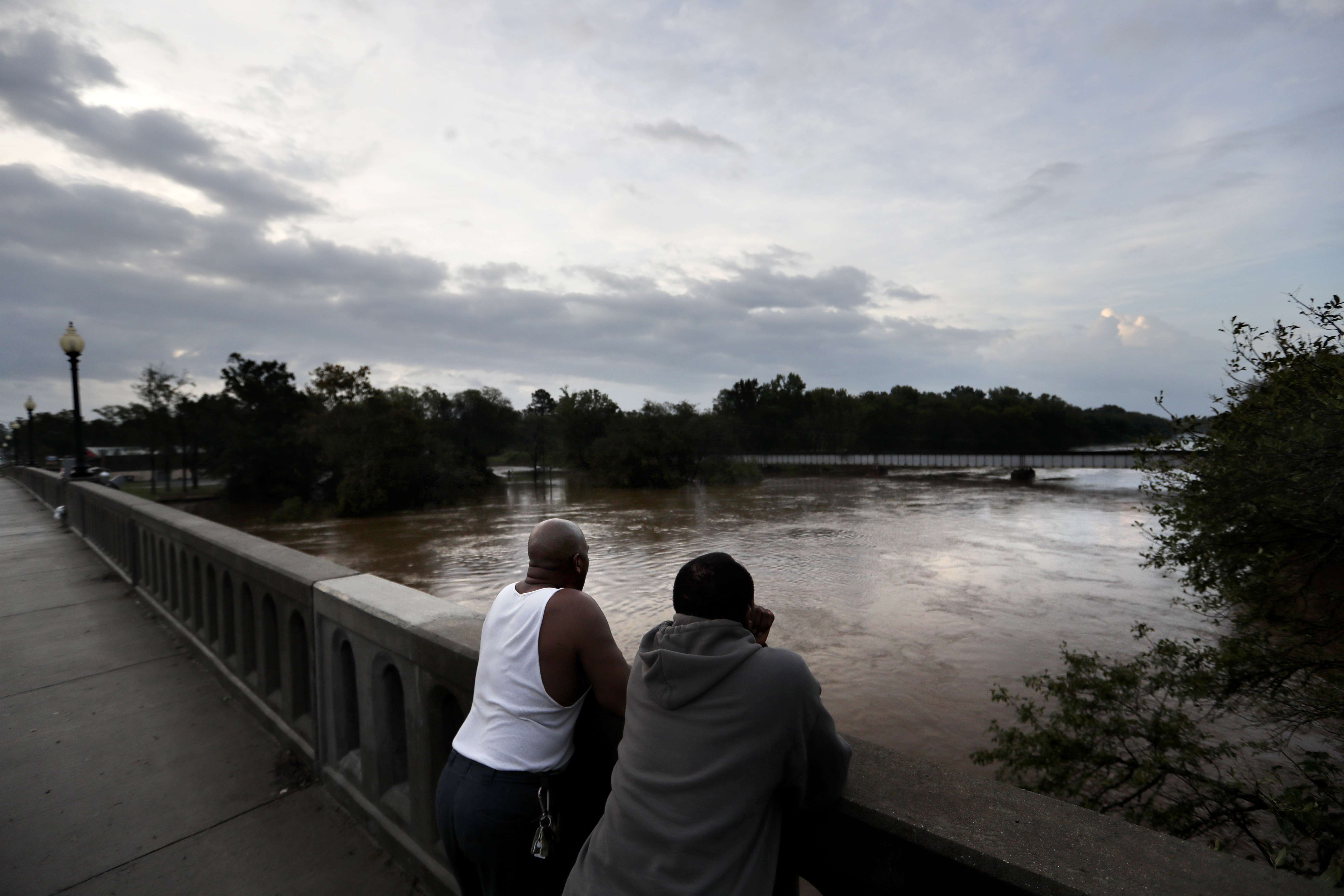 Gerald Generette, right, and Maurice Miller look onto the Cape Fear River as it continues to rise in the aftermath of Florence in Fayetteville, N.C., Monday, Sept. 17, 2018.