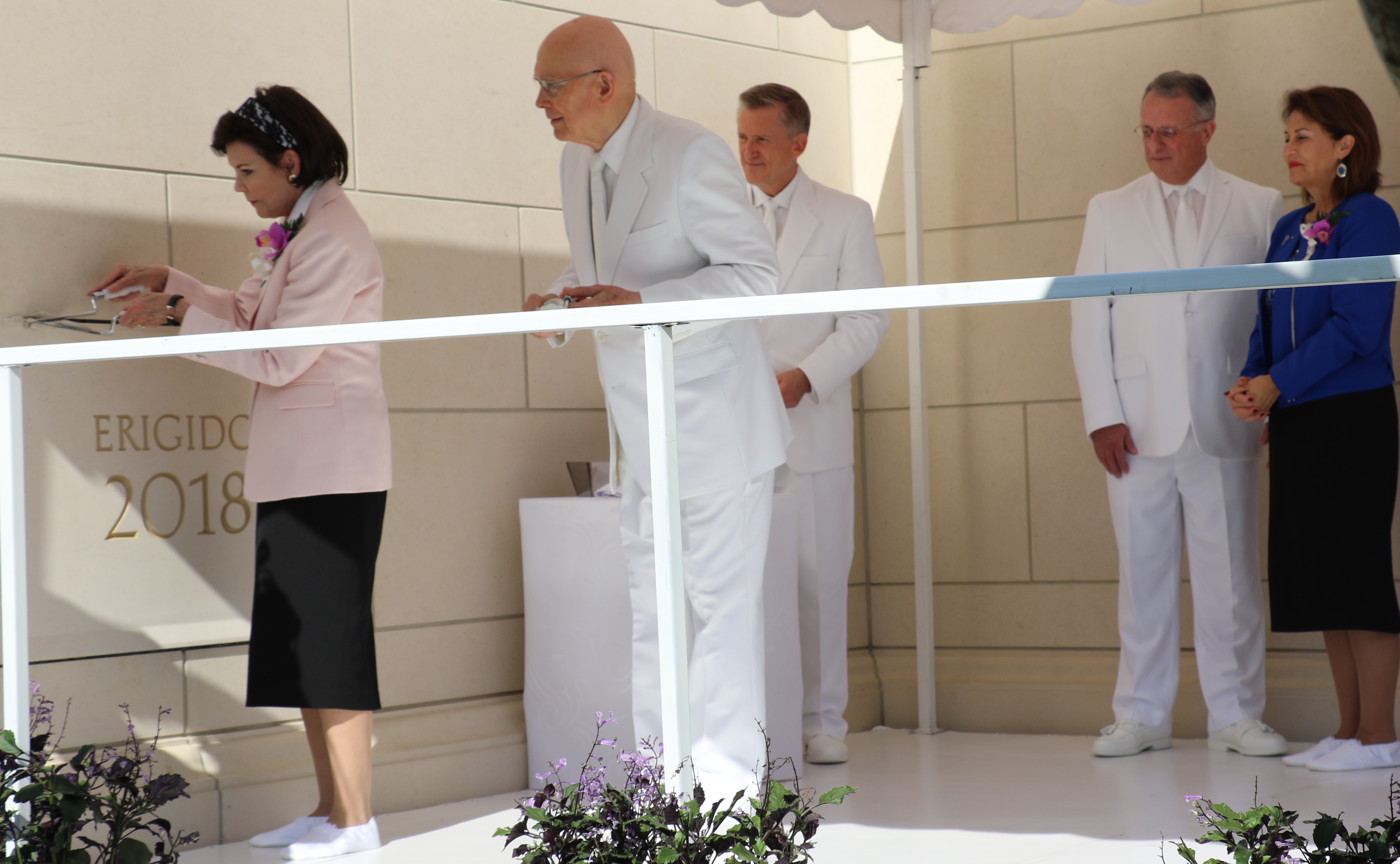 Sister Kristen Oaks, left, places some mortar on the temple capstone under the watch of her husband, President Dallin H. Oaks of the First Presidency during the Sunday, Nov. 9, 2018, dedication of the Barranquilla Colombia Temple. At right are Elder Ulisses Soares and his wife, Sister Rosana Soares.
