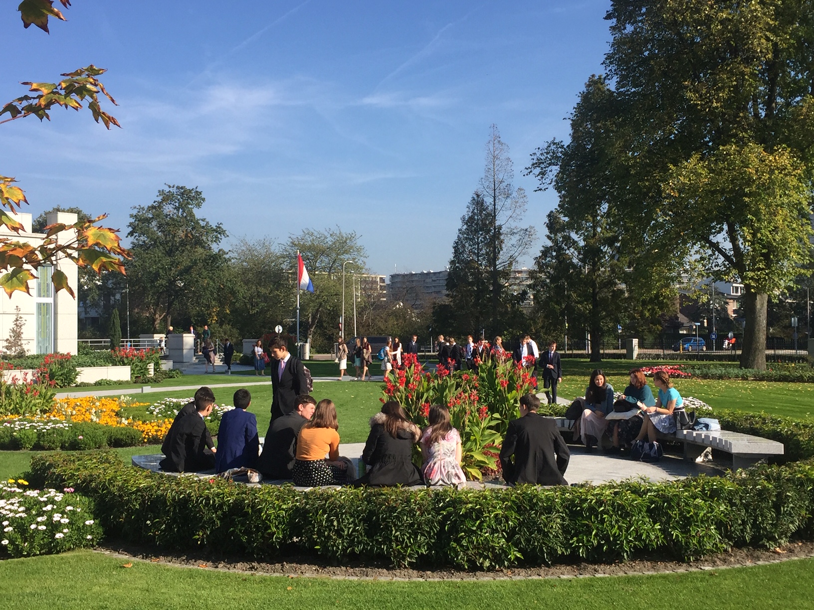 Youth from the Friedrichsdorf Germany Stake sit on the grounds of The Hague Netherlands Temple during the stake's October 2018 temple trip.