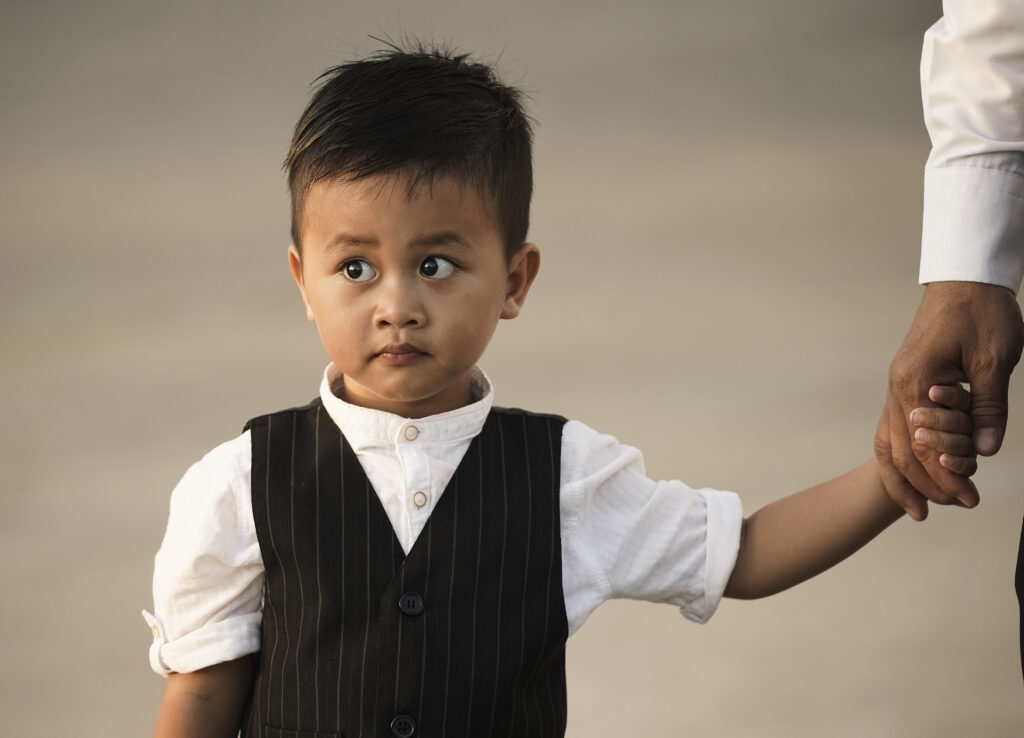Tola Udom, 2, holds his father's hand waiting for a devotional for The Church of Jesus Christ of Latter-day Saints in Phnom Penh, Cambodia, on Nov. 19, 2019.