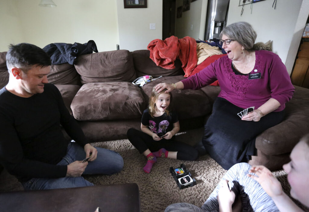 Jesse Kinman, his daughter Jade Wilkie, mother Diane Kienholz, and daughter Jordan Wilkie play Uno at Kienholz's home in Puyallup, Wash., on Sunday, Jan. 26, 2020. Kinman is homeless but often spends Saturday night at his mother's house with his daughters.