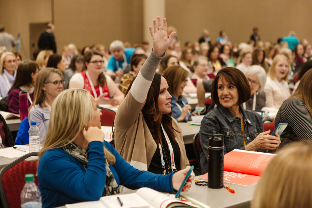 An attendee raises her hand at Light Keepers, a RootsTech event for Latter-day Saint women at the Salt Palace Convention Center in Salt Lake City on Feb. 28, 2020.