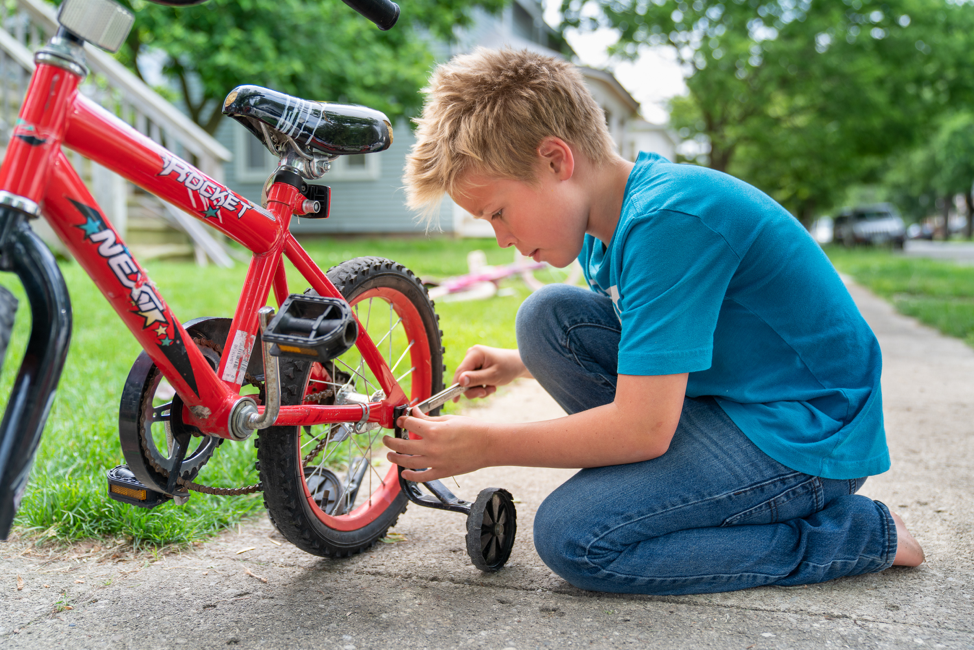 Um menino de uma estaca piloto em Columbus, Ohio, trabalha em sua bicicleta como parte do programa para Crianças e Jovens.