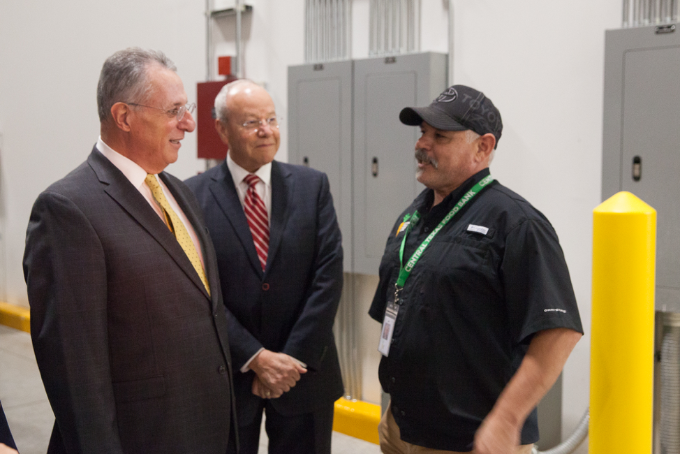 Élder Ulisses Soares conversa com um funcionário do Central Texas Food Bank durante uma visita em 18 de outubro de 2019.