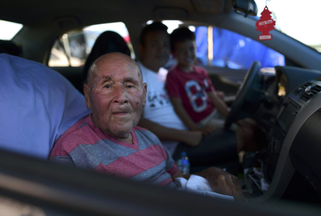 Em uma foto da sexta-feira, dia 10 de janeiro, Angel Luis Pacheco, de 83 anos, se senta com sua família dentro de um carro estacionado em uma fazenda de feno, onde residentes do bairro Índios de Guayanilla, Porto Rico, fizeram um abrigo após os últimos terremotos e em meio aos tremores secundários em Guayanilla, Porto Rico. Um terremoto de magnitude 6,4, que derrubou e danificou centenas de casas no sudoeste de Porto Rico, está causando preocupações sobre onde as famílias desabrigadas irão morar, enquanto a ilha ainda luta para se reconstruir depois do Furacão Maria, ocorrido há dois anos.