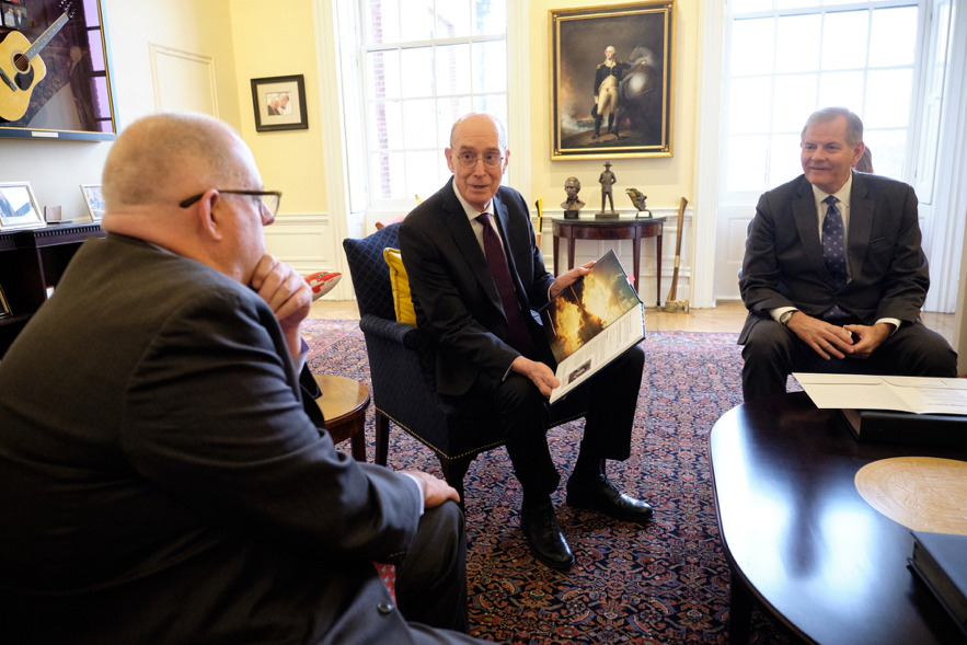 El presidente Henry B. Eyring, al centro, y el élder Gary E. Stevenson entregan una historia familiar personal al gobernador de Maryland, Larry Hogan, el 15 de noviembre del 2019.
